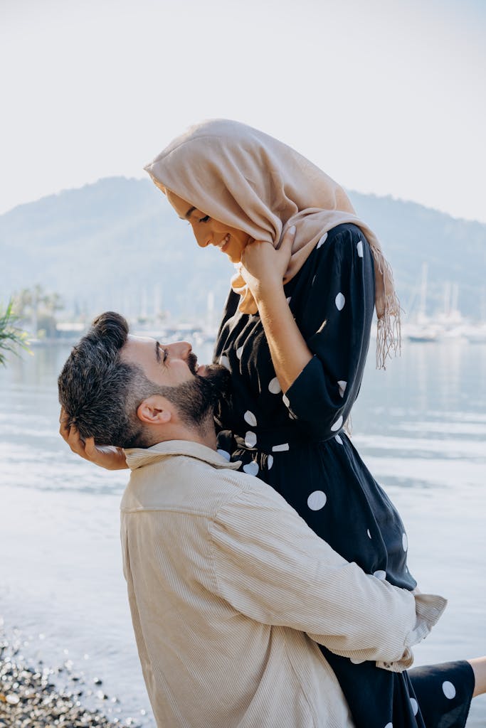 Photo of a Lovely Couple Standing Near a Body of Water